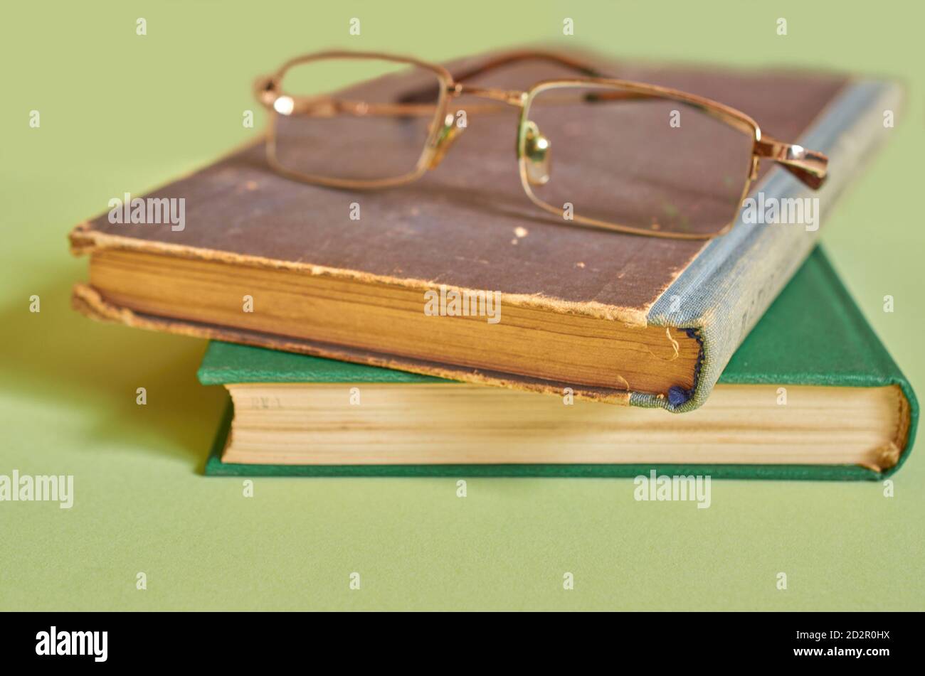 The glasses are on top of a stack of old books. Close-up, macro Stock Photo