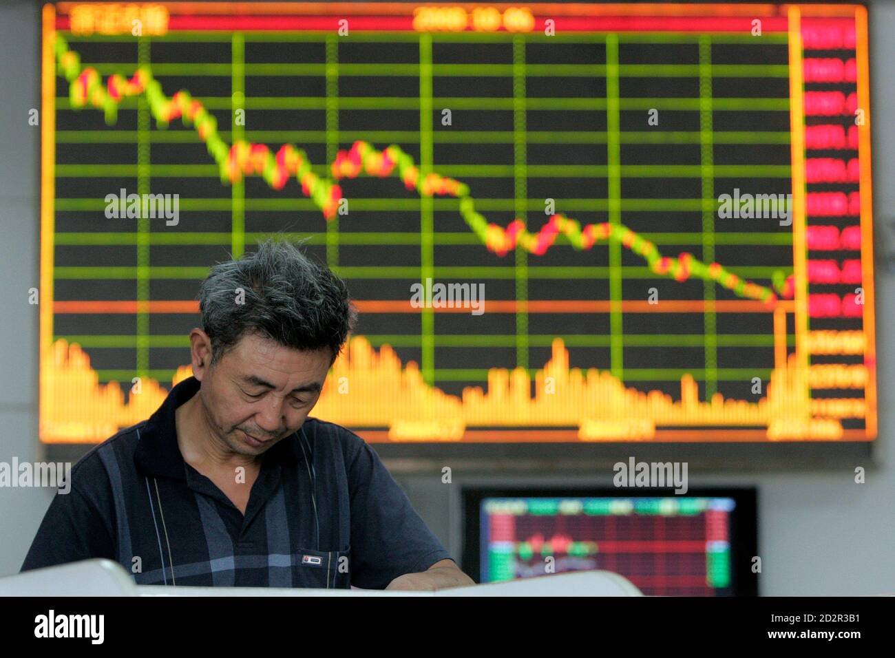 A man reads information on an electronic screen at a brokerage house in Shanghai October 6, 2008. China's stock market, resuming trade on Monday after a week-long national holiday, opened lower in response to sliding overseas markets and fears of a global economic slowdown. REUTERS/Aly Song (CHINA) Stock Photo