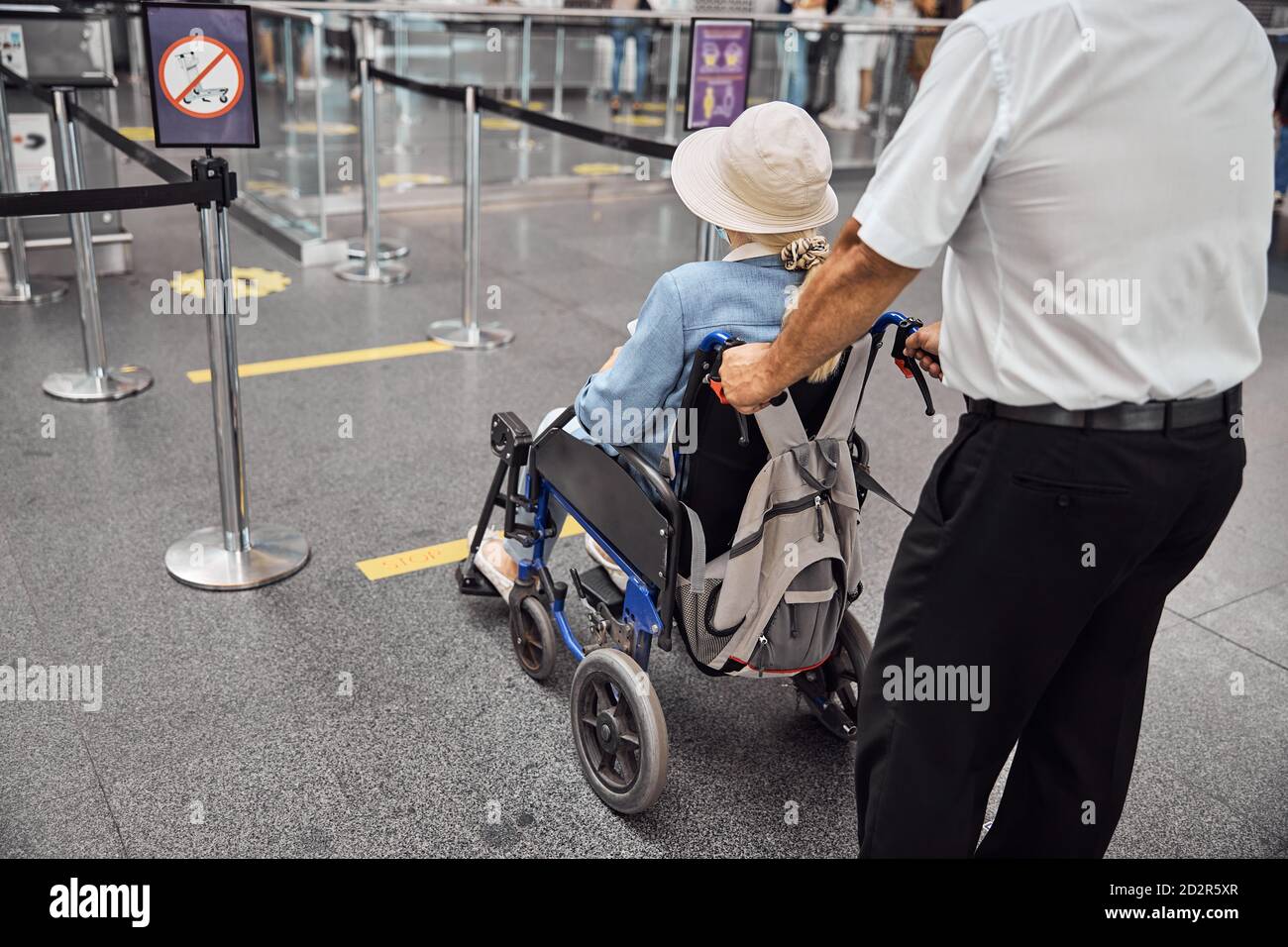 Airline worker rolling a wheelchair with a senior lady Stock Photo Alamy