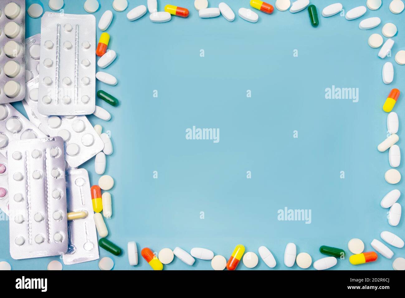 Mockup for medical theme and pharmacy. Various pills and capsules of medicines are scattered on blue background, copy space. Stock Photo