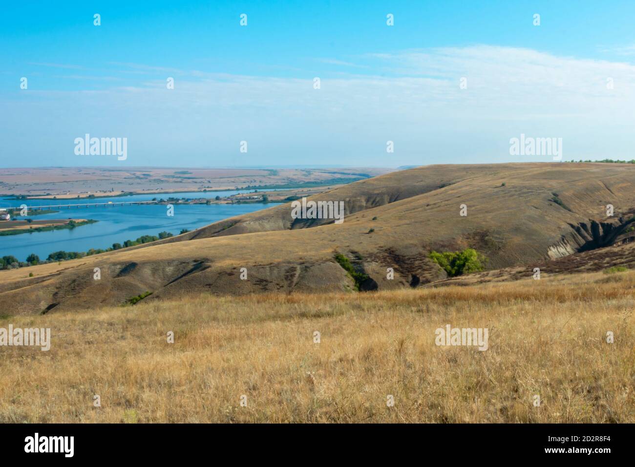 Beautiful landscape of nature. The river is meandering between the hills in the Volga steppe. Ravines and blue sky on a summer day. Soft focus. Stock Photo