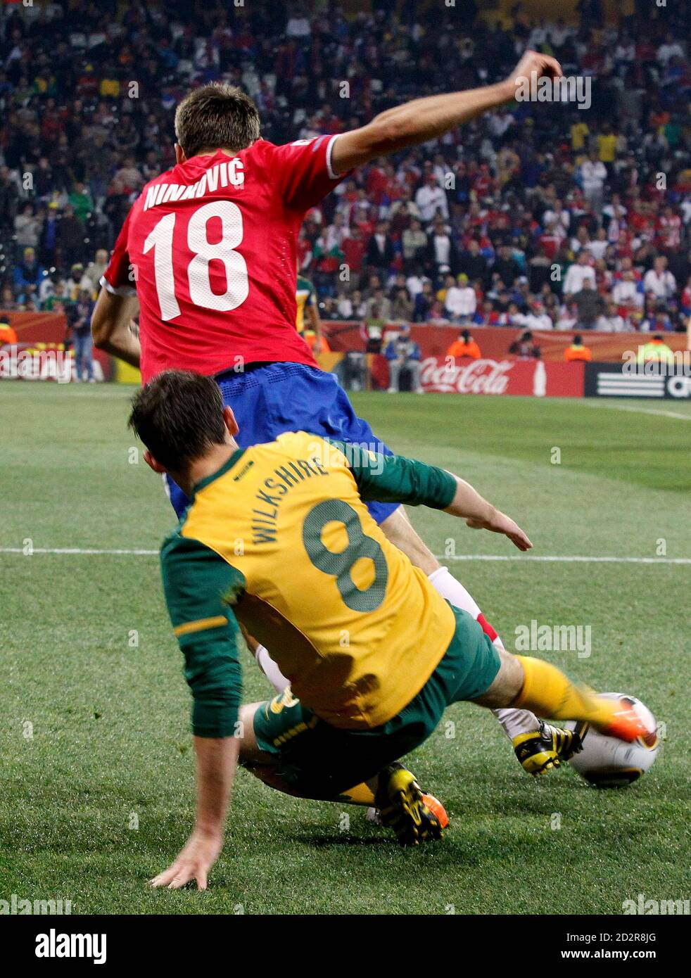 Australia's Luke Wilkshire tackles Serbia's Milos Ninkovic from behind and receives a yellow card thereafter during a 2010 World Cup Group D soccer match at Mbombela stadium in Nelspruit June 23, 2010.   REUTERS/Thomas Mukoya (SOUTH AFRICA  - Tags: SPORT SOCCER WORLD CUP) Stock Photo