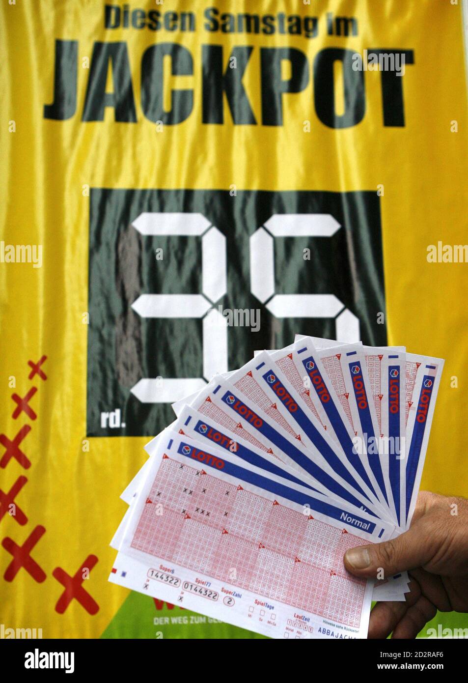 A man poses with lottery receipts in front of a sign of a Lotto receiving  office in Dortmund October 6, 2006. This Saturday the German public lottery  'Lotto' will distribute a total