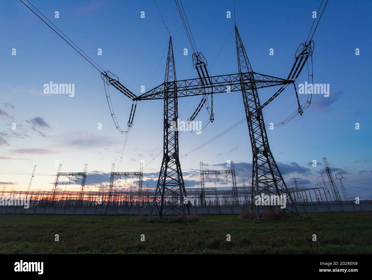 High voltage electric pole and transmission lines in the evening. Electricity pylons at sunset. Power and energy. Energy conservation. High voltage gr Stock Photo