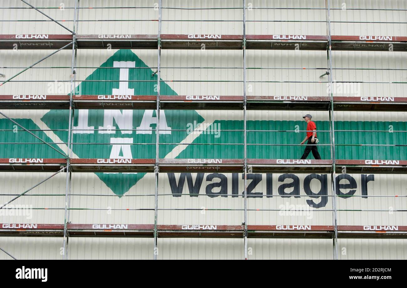 A construction worker walks near the logo of INA, a brand of German  ball-bearing makers Schaeffler Group, in Herzogenaurach in this July 16,  2008 file photo. Herzogenaurach -- called 