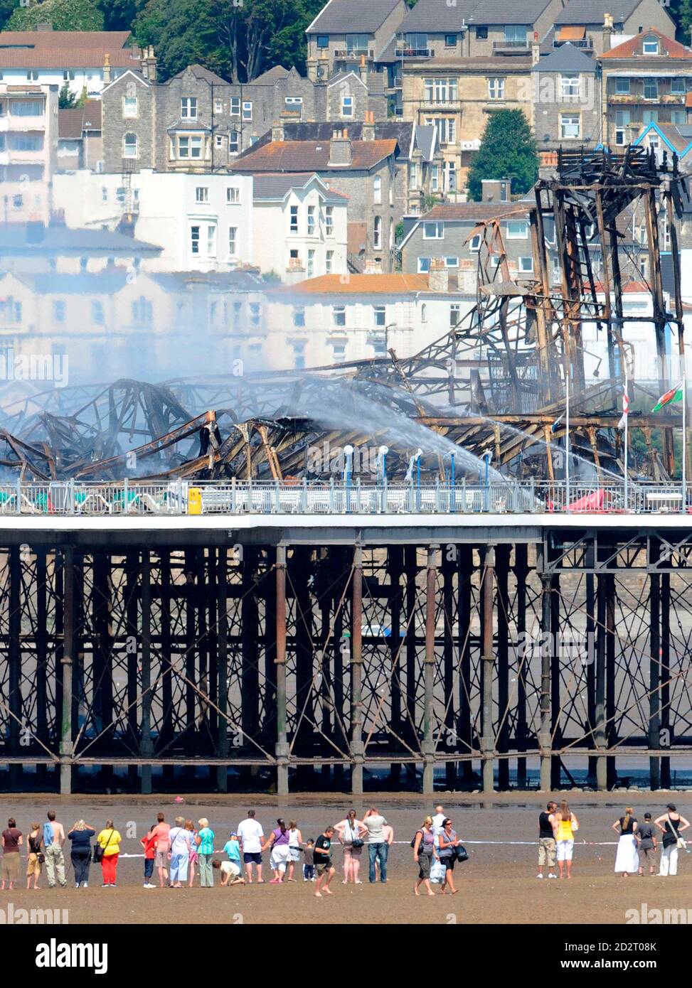 Holiday makers look at the Grand Pier at Weston-Super-Mare in south west England July 28, 2008. Firefighters were called to a large blaze that swept through the historic pier at the Somerset seaside resort of Weston-super-Mare on Monday, police said. Flames and thick black smoke engulfed the structure and could be seen from the M5 motorway, several miles from the coast, a fire brigade spokeswoman said. REUTERS/Toby Melville (BRITAIN) Stock Photo