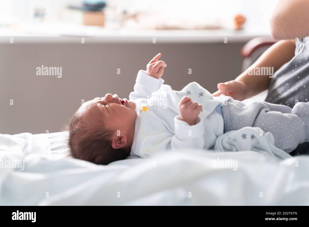 Side view of tiny crying newborn child lying near anonymous mom on bed in nursery Stock Photo - Alamy Side view of tiny crying newborn child lying near anonymous mom on bed in nursery Stock Photo - Alamy