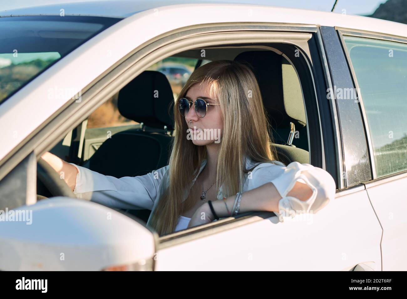 Side view of traveling Woman sitting in modern automobile during road trip Stock Photo