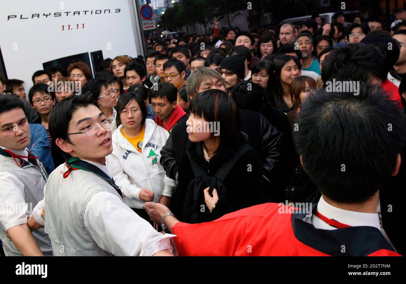 People queue to buy Sony's new PlayStation 3 (PS3) while shop assistants  stand guard at an electronics retail shop in Tokyo November 11, 2006. Sony  will roll out the latest version of