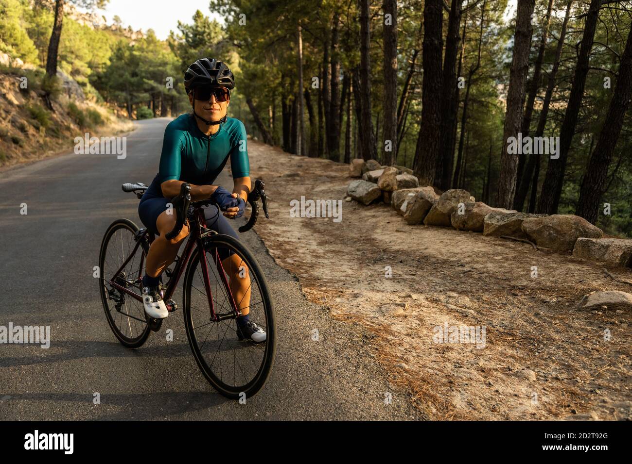 mature Woman training road bike, climbing a mountain road, resting sit