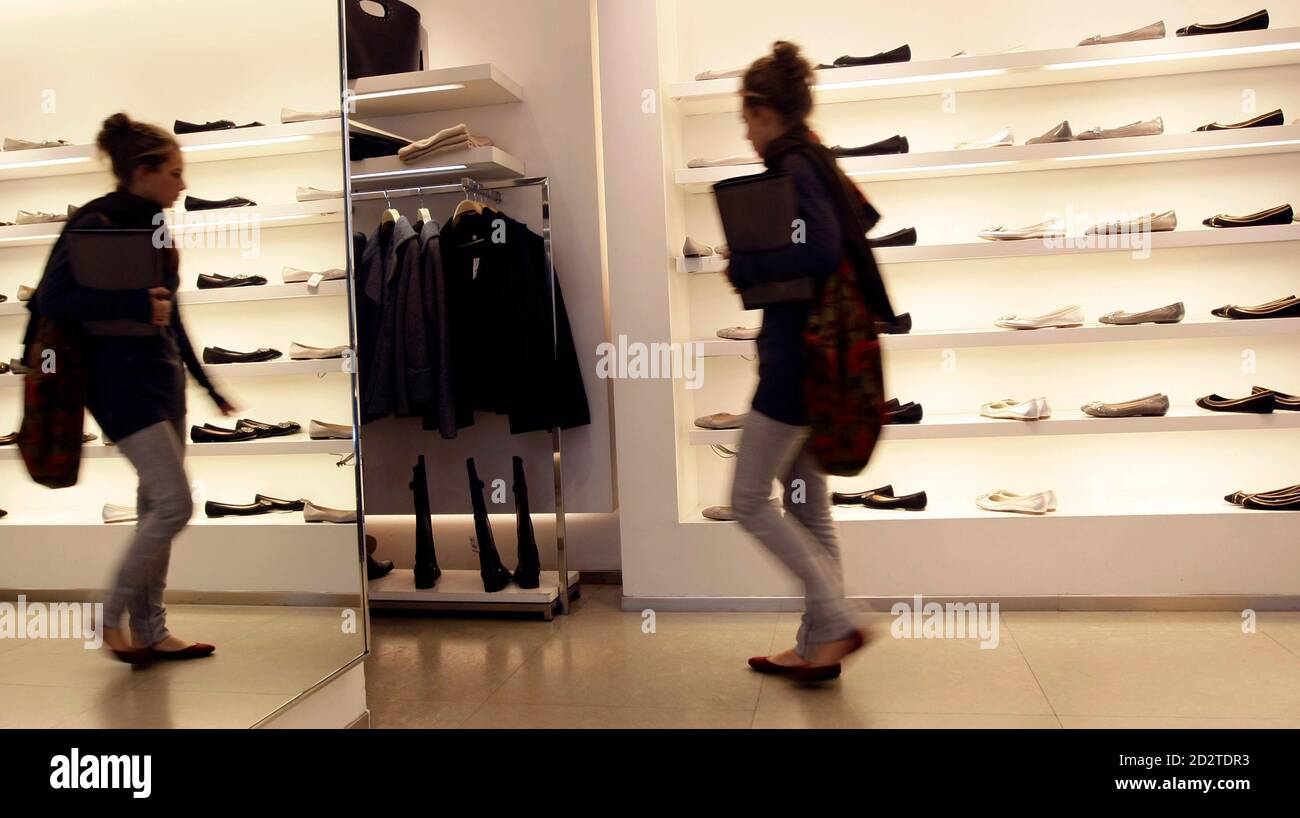 A customer walks past shoes inside a Zara store in central Madrid October  20, 2008. Every piece of Zara clothing sold in nearly 1,500 stores  worldwide passes through this cavernous distribution centre