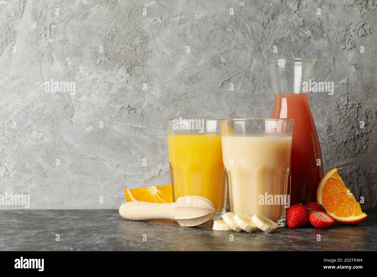 Jars with different juices against gray background Stock Photo