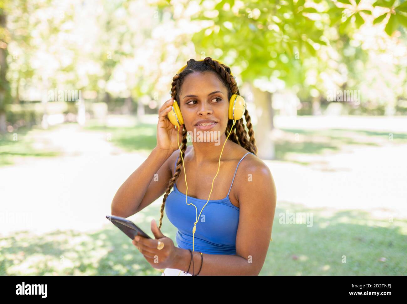 Positive Hispanic female listening to music in headphones while ...