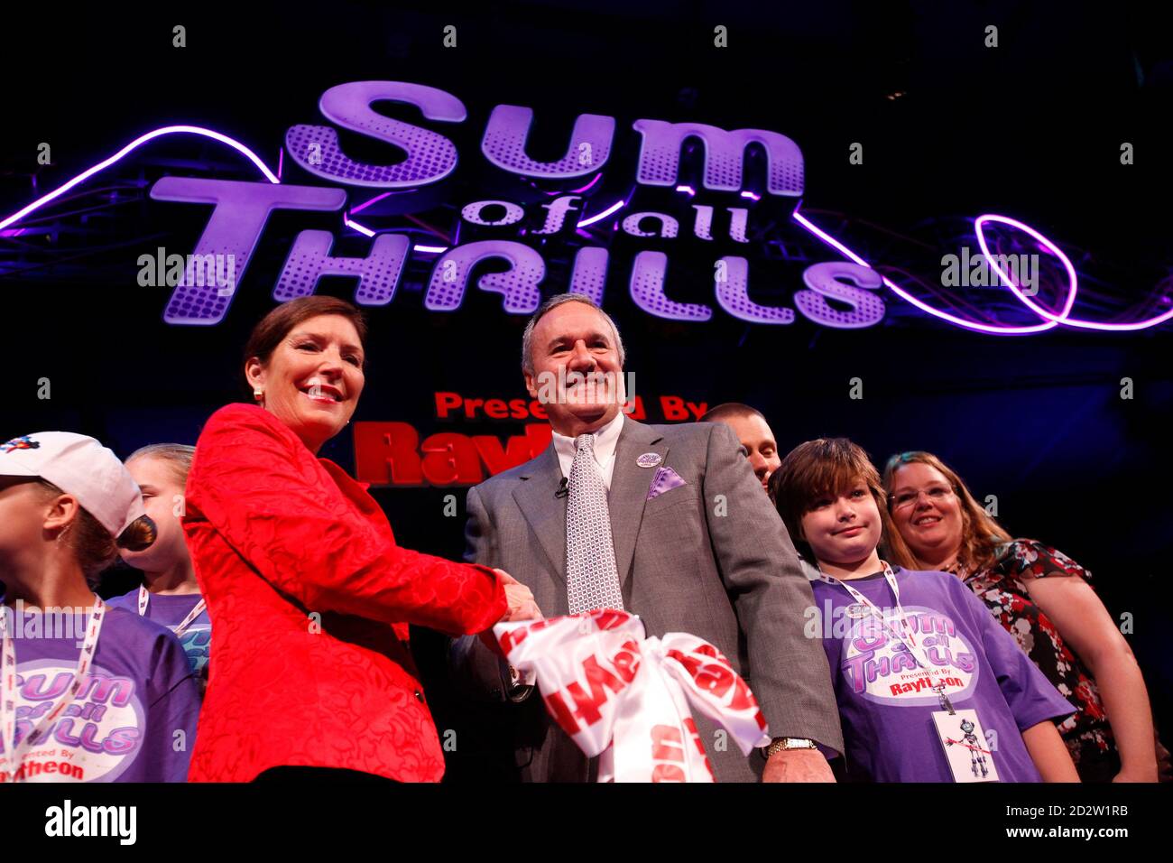Raytheon CEO Bill Swanson (R) shakes hand with Walt Disney World Resory president Meg Crofton during the grand opening of the Sum of all Thrills in INNOVENTIONS at Epcot Center at the