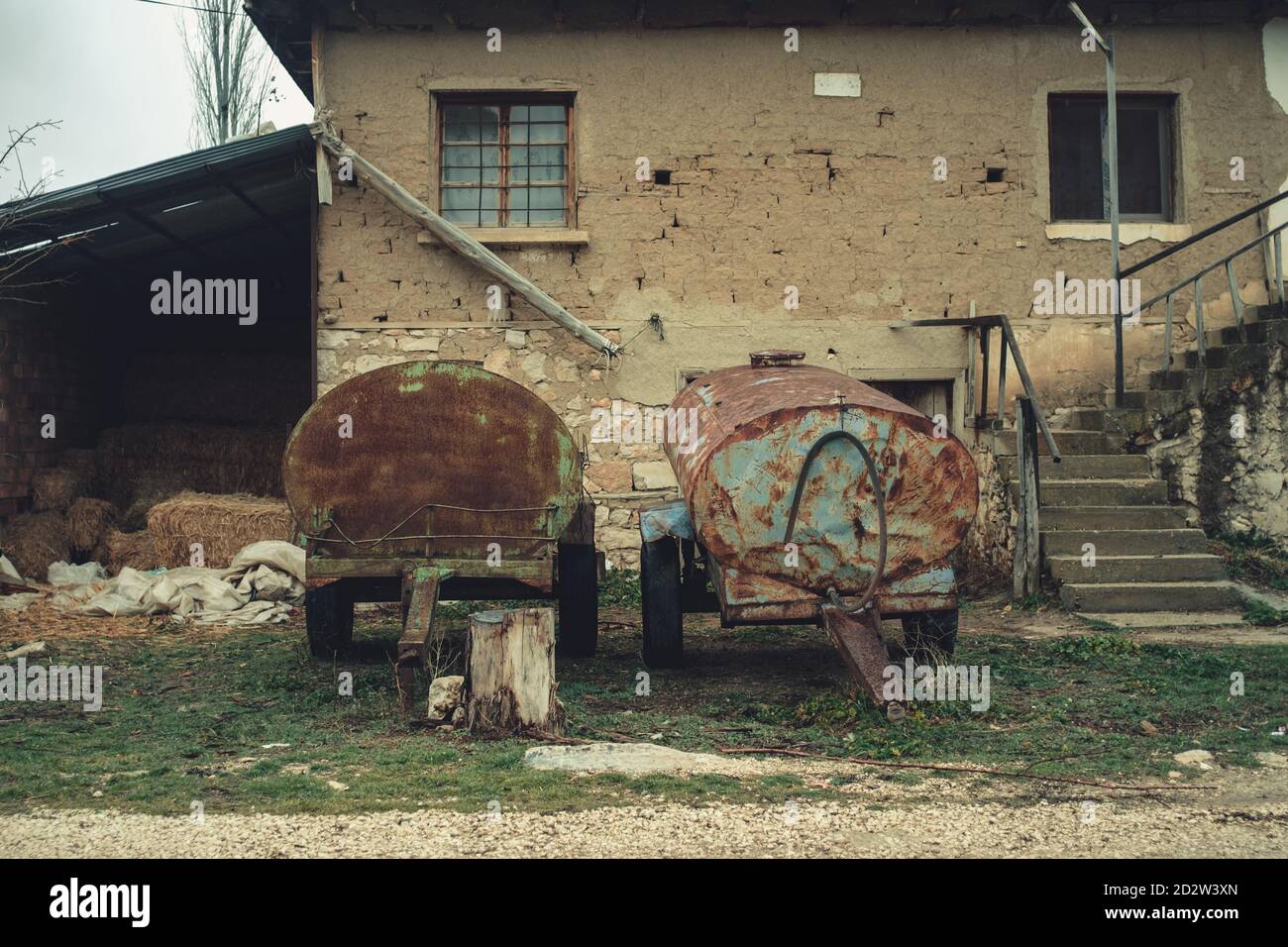 Antalya, Turkey – 23rd February 2020: Old rusty water tanks on the wheels Two aged tanks in front of the house. Stock Photo