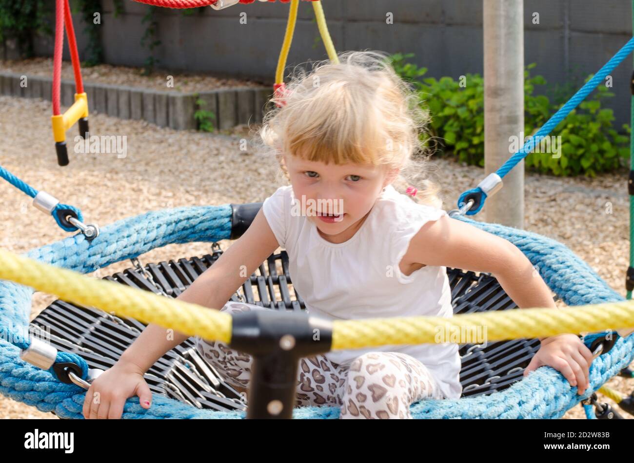beautiful blond girl playing on playground Stock Photo