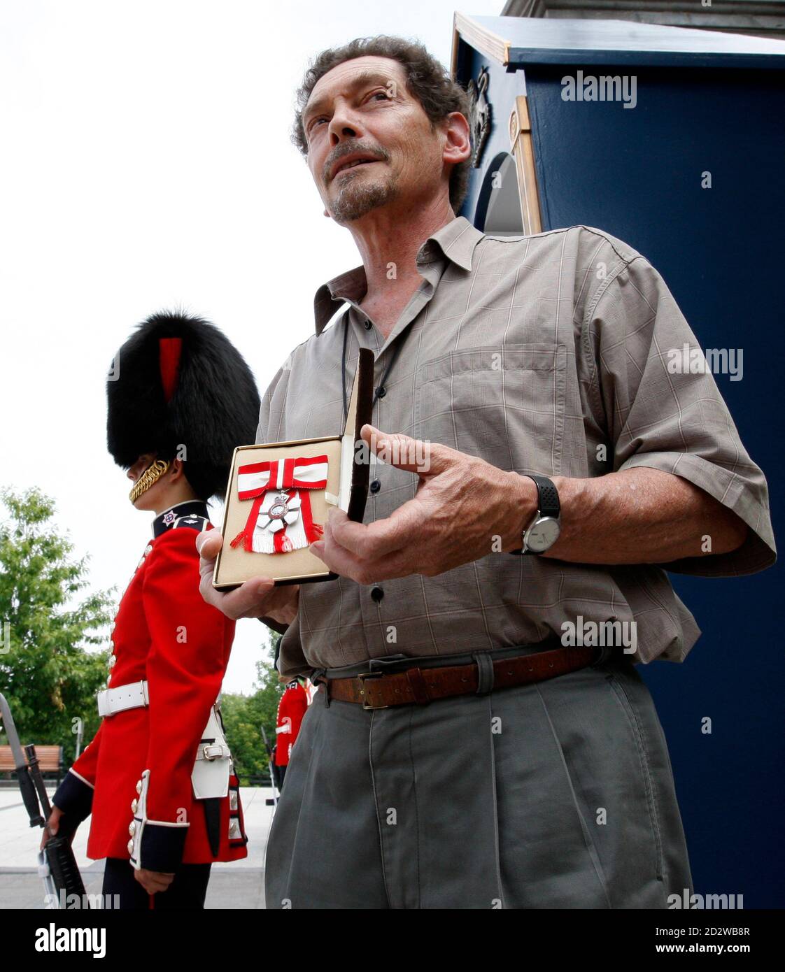 Mark Schlingerman, a director general of the Catholic group Madonna House, holds an Order of Canada medal that was awarded to the group's late founder, Catherine Doherty, outside the front gates of Rideau Hall in Ottawa July 8, 2008. The group returned the medal to protest the naming of Henry Morgentaler, the doctor who led the fight to legalize abortion in Canada two decades ago, to the country's highest civilian award.       REUTERS/Chris Wattie       (CANADA) Stock Photo