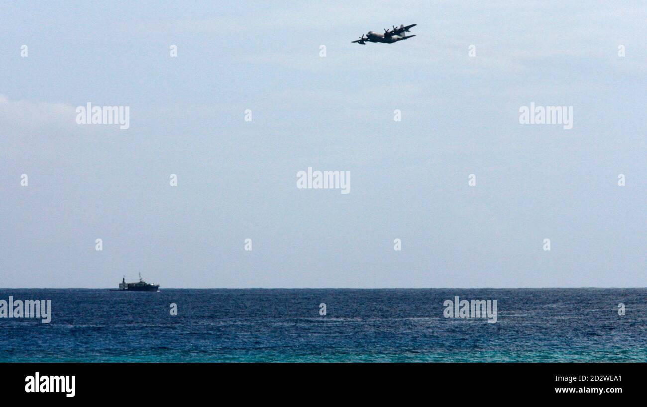 A U.S. military C-130 plane and a naval ship participate in the search mission for the missing Yemenia A310-300 plane that crashed in Mitsamiouli, 30km north of Comoros' capital Moroni July 3, 2009. The sole survivor of a Yemeni jet that plunged into the Indian Ocean off the Comoros islands was reunited with her father in France on Thursday, but rescuers said hopes of another miracle find were all but over. REUTERS/Thomas Mukoya (COMOROS DISASTER) Stock Photo