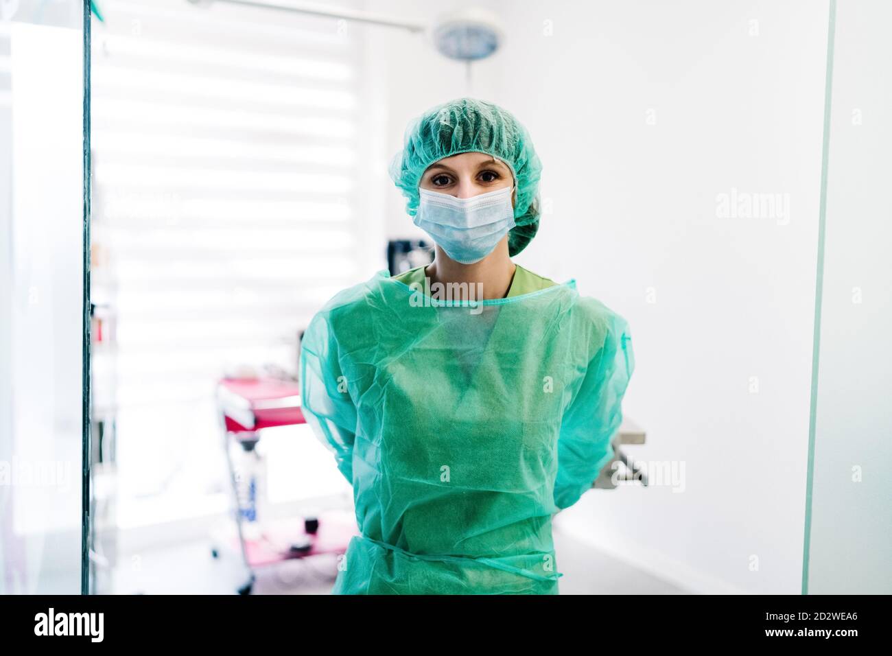 Serious female vet surgeon in mask and uniform preparing for operation