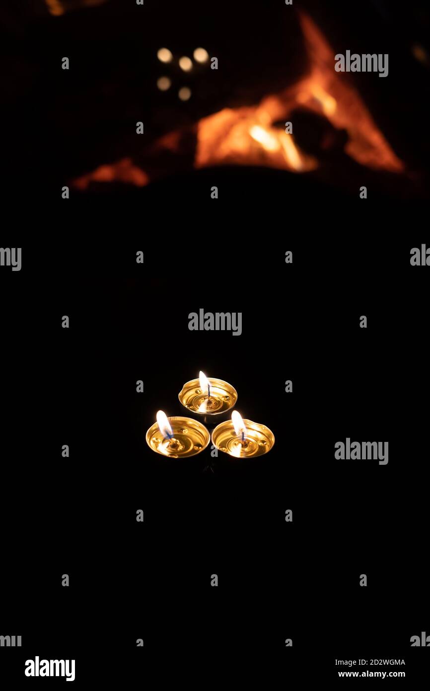 three candles on a black background with a fireplace flame Stock Photo ...
