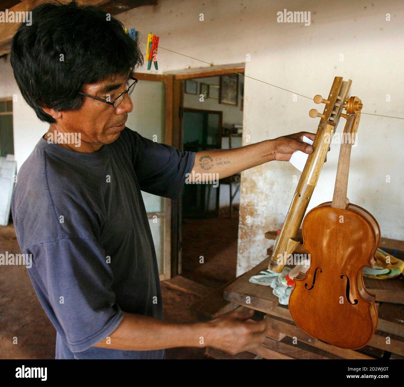 Native Bolivian Violin Maker Hilderio Azogue Compares A Taquara Or A Native Violin With A Violin He Is Finishing In The Eastern Bolivia Village Of Urubicha 270 Km 168 Miles North Of Native Bolivian Violin Maker Hilderio Azogue Compares A Taquara Or A Native Violin With A Violin He Is Finishing In The Eastern Bolivia Village Of Urubicha 270 Km 168 Miles North Of