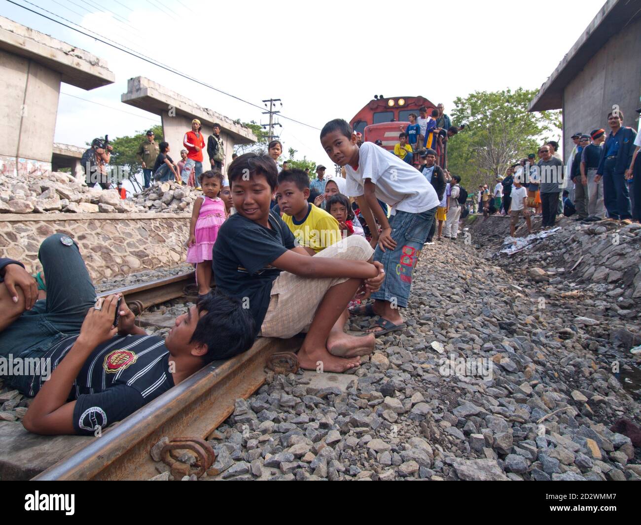SIRING, SURABAYA, JAVA, INDONESIA - FEB 22, 2007: Demonstraters block the railway near the destroyed village of Siring near Surabaya,  Java, Indonesia Stock Photo