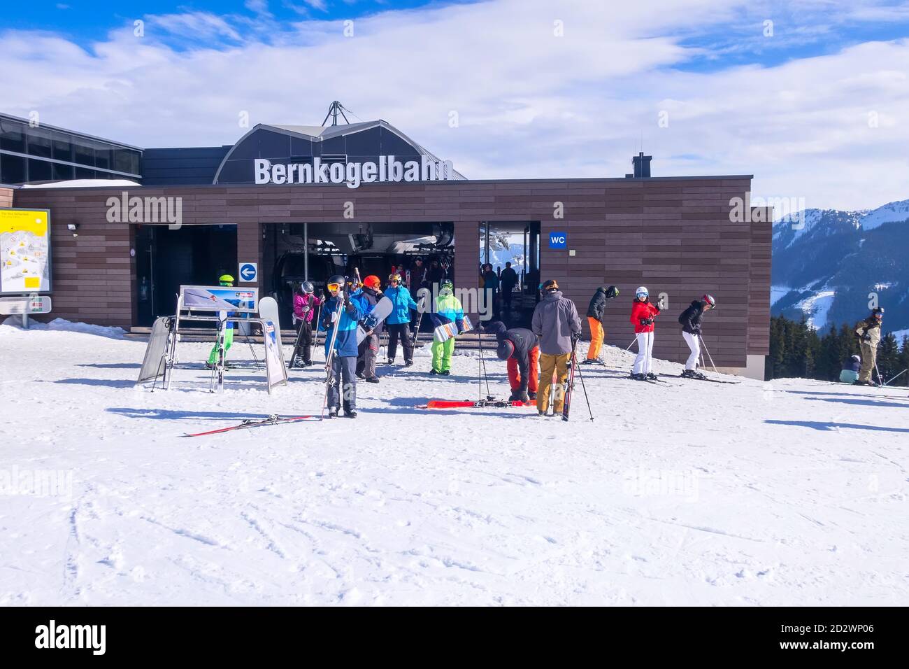 Saalbach, Austria - March 1, 2020: People going skiing from cable car ski lift Bernkogelbahn station Stock Photo