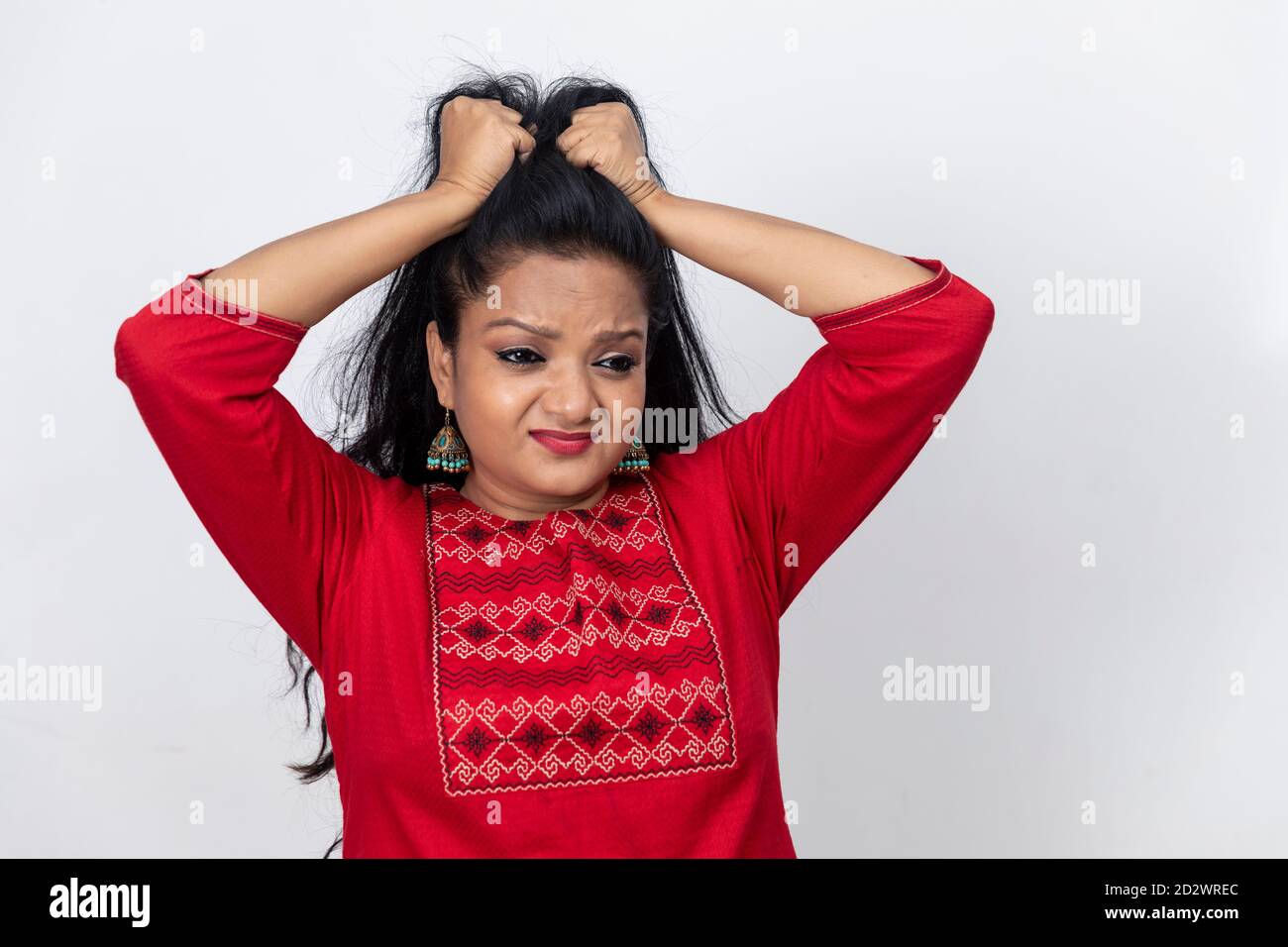 Portrait Of Indian Woman With Her Fingers In Her Long Hair And Pulling At Them Angry And