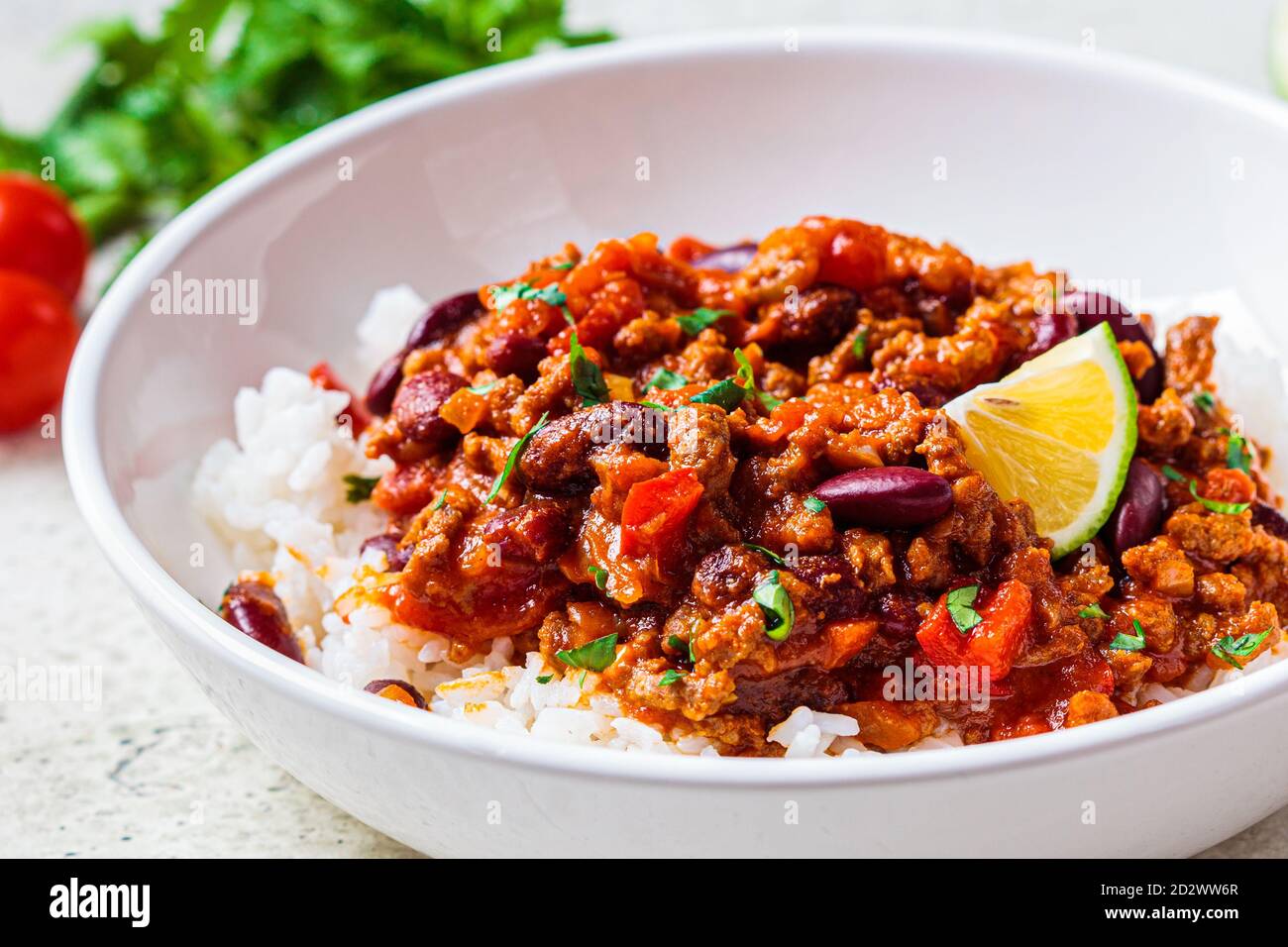 Chili con carne with rice in a white bowl. Beef stew with beans in tomato sauce and rice
