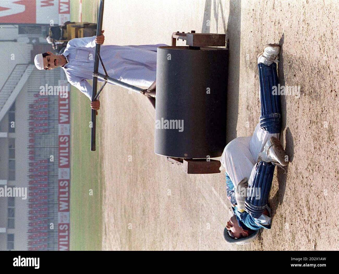 England wicket keeper Jack Russell exercises while ground staff roll the wicket at the Peshawar