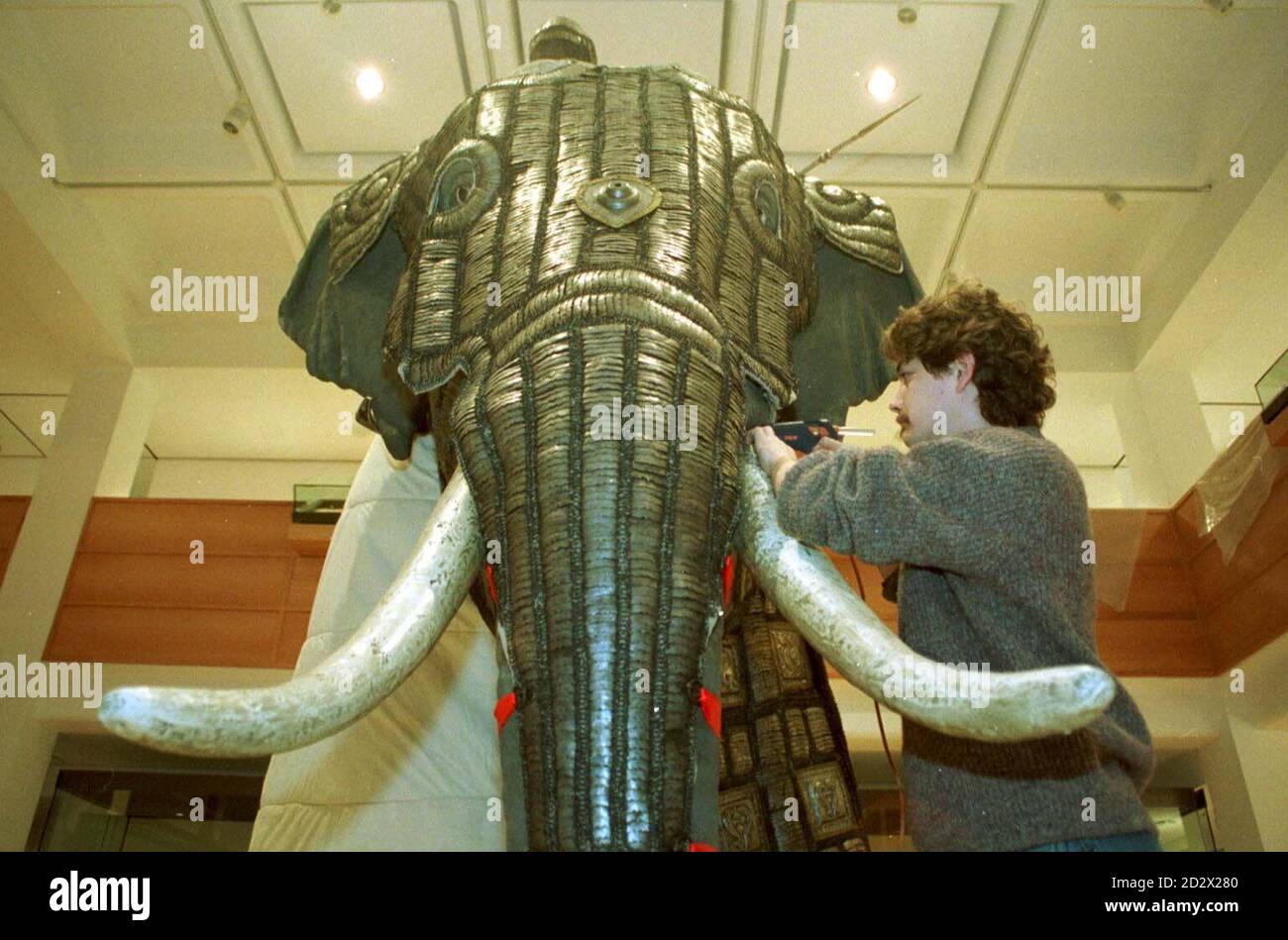Royal Armouries assistant curator Chris Henry puts final touches to the largest suit of armour in the Royal Armouries' collection which was made for an elephant in the late 16th century. This is just one of the pieces that will be seen by the Queen when she opens the museum, in Leeds. Stock Photo