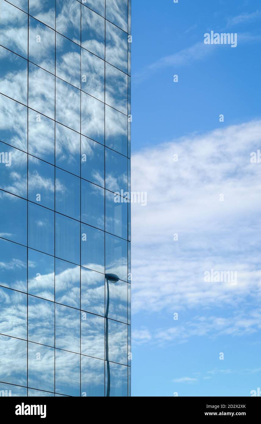 A glass facade reflects the blue sky and white clouds Stock Photo - Alamy