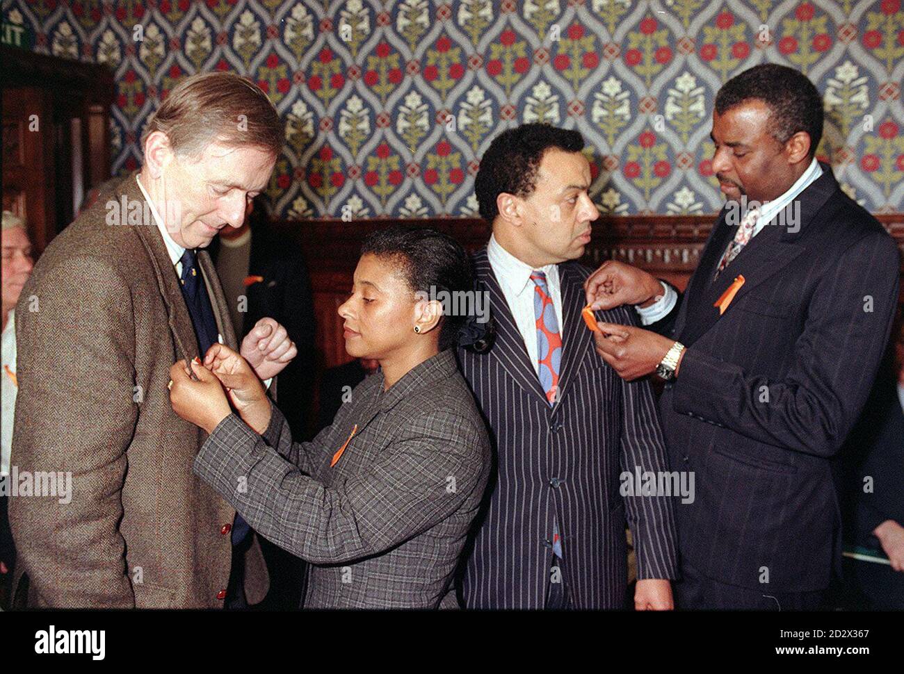 Neville and Doreen Lawrence, parents of murdered teenager Stephen Lawrence, pin a 'Torrid orange' ribbon on MPs Peter Bottomley (left) and Paul Boateng in the Jubilee Rooms of the House of Commons today (Monday), where they launched the Ribbon in memory of their son. April 22nd is the third anniversary of Stephen's murder. During the previous week, on April 16, three youths will face charges of murder at the Old Bailey, when Neville and Doreen's unprecedented private prosecution commences. Stock Photo