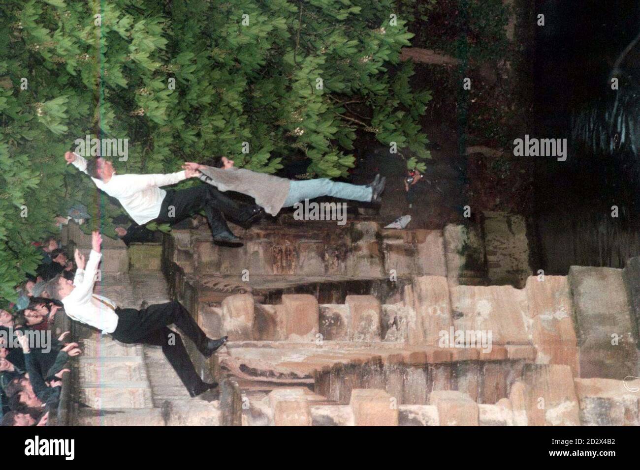 Student revellers jump from the Magdalen bridge in Oxford into the Cherwell River for the traditional celebration of the 1st of May. Stock Photo