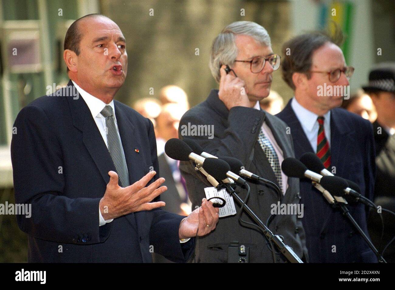 Prime Minister John Major holds his earpiece as he listens attentively as French President Jacques Chirac speaks to the media outside 10 Downing St. Stock Photo