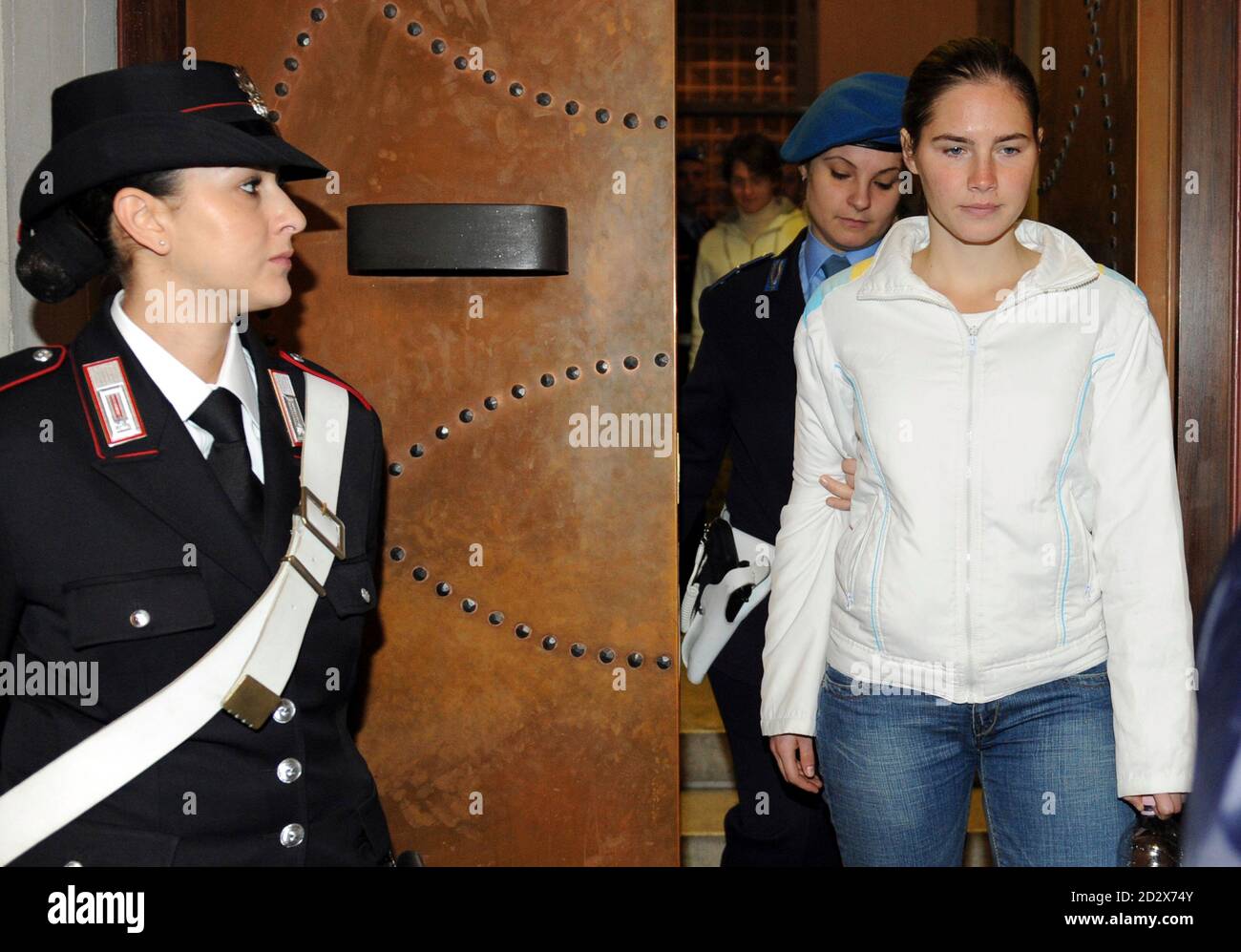 American university student Amanda Knox (R) is escorted into the courtroom during a murder trial session in Perugia November 28, 2009. Defendants Knox and her Italian ex-boyfriend Raffaele Sollecito are on trial for the murder of British student Meredith Kercher in November 2007. REUTERS/Alessandro Bianchi   (ITALY CRIME LAW) Stock Photo