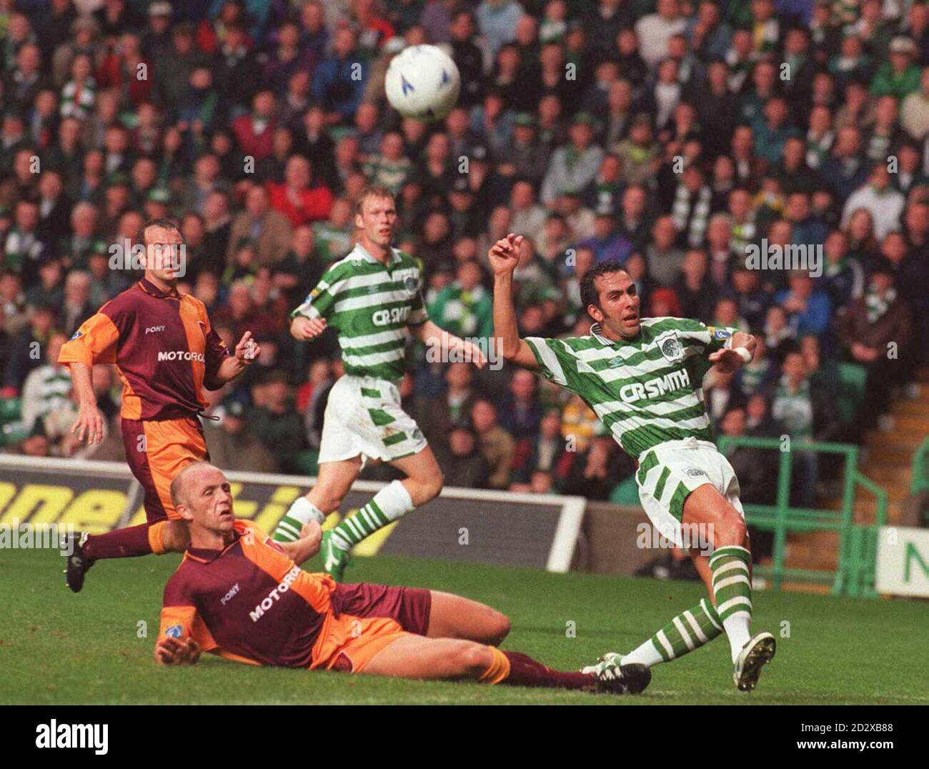 Motherwell's Brian Martin slides in to tackle Celtic's Paolo Di Canio, during their Scottish Premiership match today (Saturday). PA Photos. Stock Photo