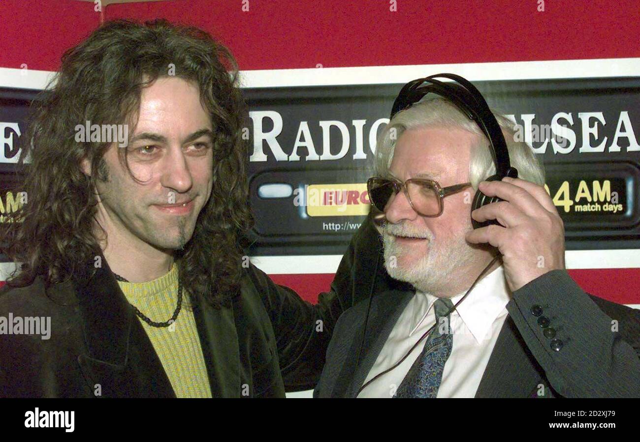 Chairman of Chelsea Football club Ken Bates (right) has a set of headphones  put on by Bob Geldof during a press conference to anonunce the start of the  new radio station, 'Radio