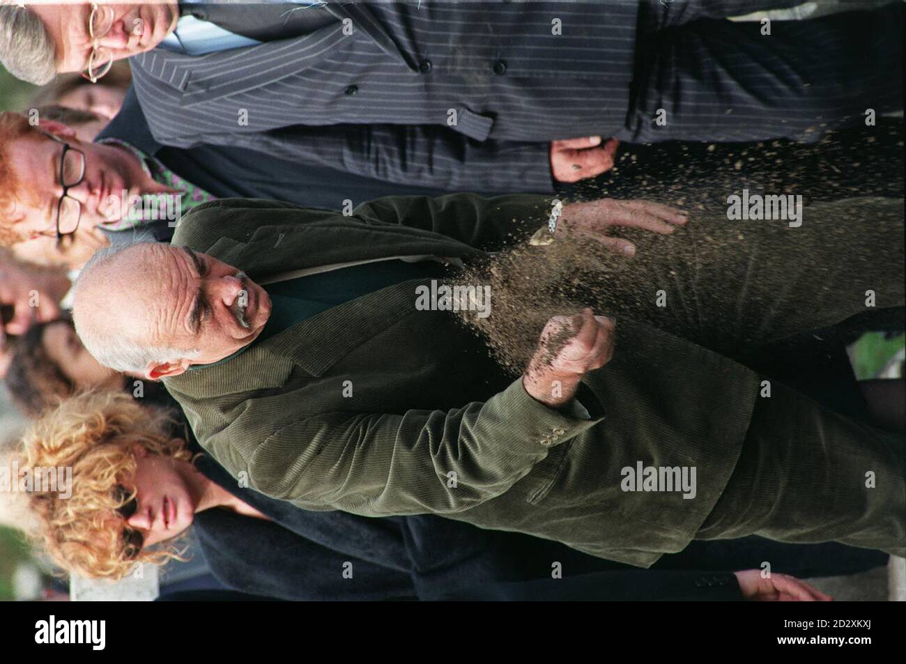 Hollywood star Sean Connery throws a handful of earth on to the coffin