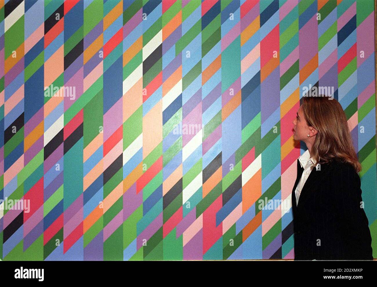 Monica Campos, a specialist of Christies' contemporary art department, admires work by English artist Bridget Riley entitled "Certain Day", in London today (Weds), previewing the Contemporary Art Sale of 20th Century pictures, drawings and sculpture from rock legend Eric Clapton's collection, which hopes to fetch 30,000- 40,000, at the auction with the entire collection estimated at 300,000- 500,000, on May 29. Photo by Helen Tilley. * 2/7/03: An art expert admiring work by English artist Bridget Riley entitled "Certain Day" as Riley and influential film-maker Ken Loach were among five Stock Photo