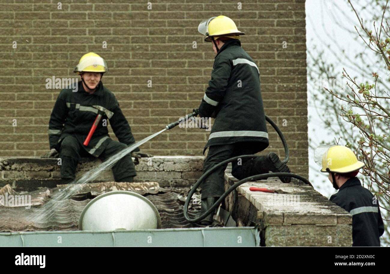 Firefrighters cool down hot tiles on the roof of St MacNissis Roman Catholic Church at Randalstown, Co Antrim, this morning (Sat), after a fire which is believed to have been started deliberately. See PA Story ULSTER Church. Photo by PA. Stock Photo