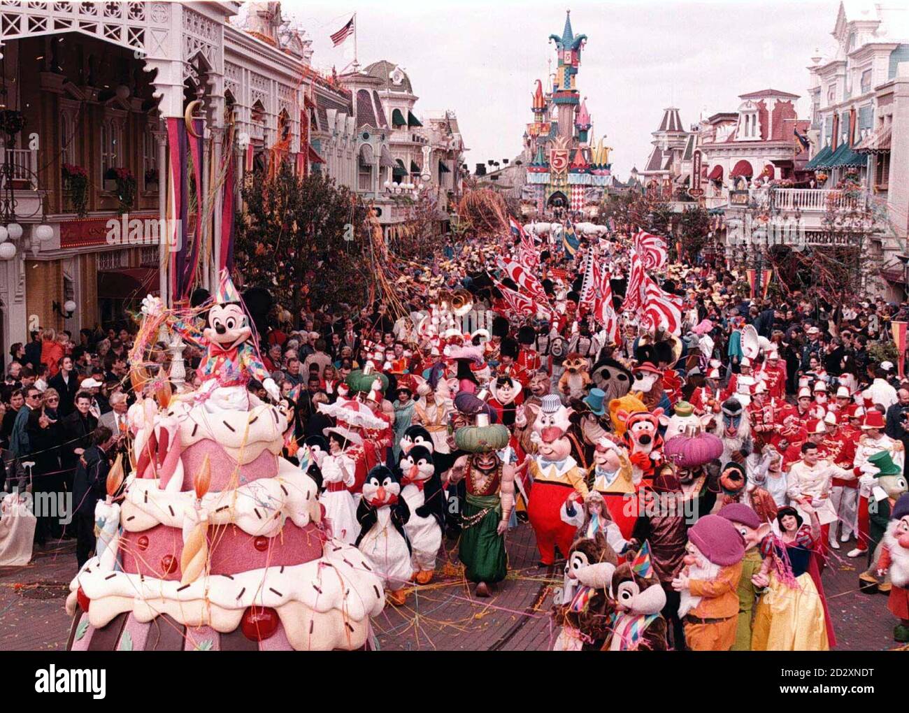 Mickey Mouse left pops out of a giant birthday cake at the front of the Grand Parade to mark the 5th birthday of Disneyland Paris this afternoon Saturday Photo by John Stillwell PA