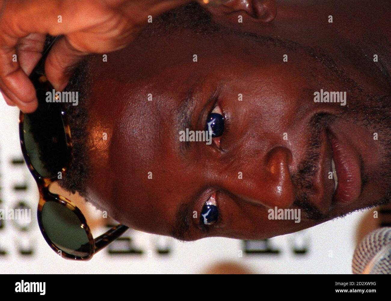 Bkritish sprinter Linford Christie lifts his sunglasses to reveal a pair of Puma  contact lenses during a news conference in Atlanta this morning (Thursday).  Photo by John Giles/PA Stock Photo - Alamy