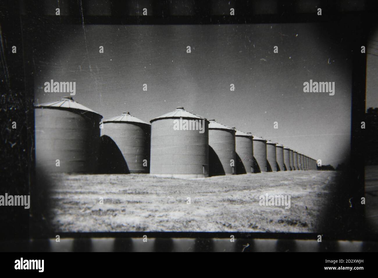 Fine 1970s vintage black and white photography of a row of huge storage silos. Stock Photo