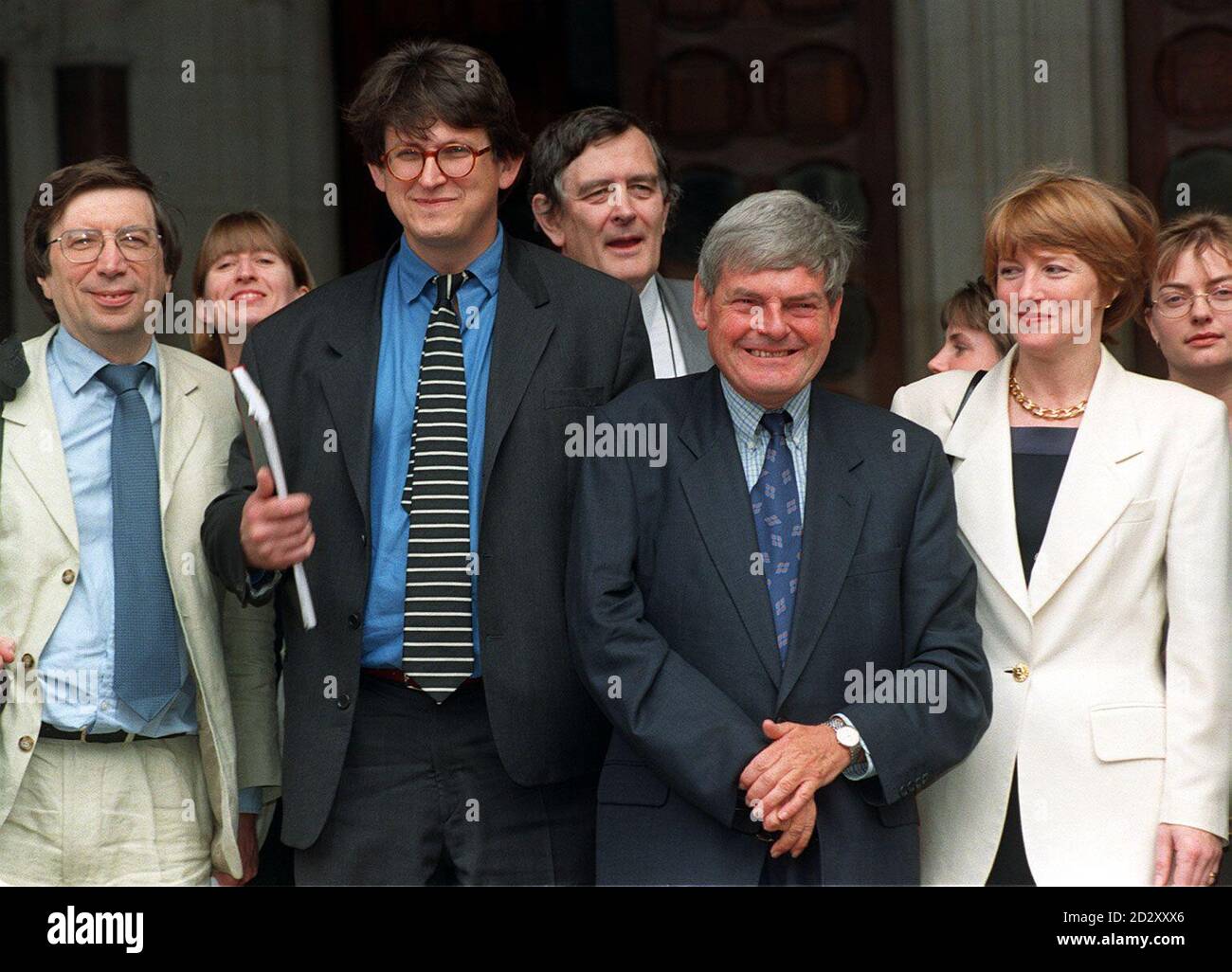 Guardian editor, Alan Rusbridger (2nd from left) and former  editor, Peter Preston, (3rd from left) with their jubliant team outside the High Court in London today (Friday) after Jonathan Aitken's libel action over their allegations in April 1995 that he was financially dependent upon the Saudis collapsed this morning.  Mr Aitken faces public humiliation after making the dramatic decision to discontinue his libel action in the face of last-minute evidence that he had lied to the High Court.  See PA stories under COURTS Aitken.  Photo by Stefan Rousseau/PA. Stock Photo