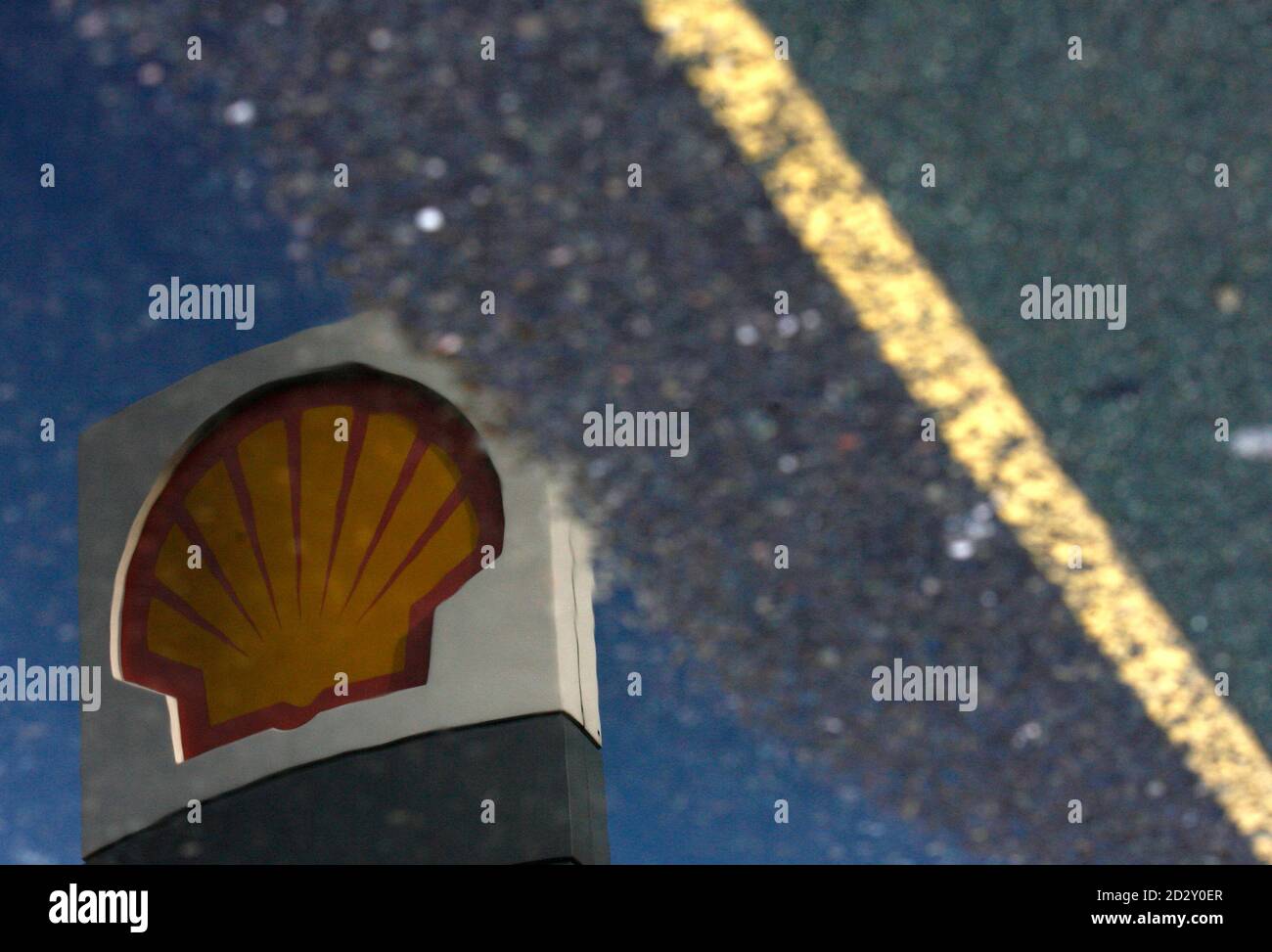A Shell petrol station sign is reflected in a puddle in London April 28, 2009. Royal Dutch Shell Plc followed an oil industry trend of reporting sharply lower first-quarter profit due to lower crude prices, while outperforming analysts' forecasts.  Shell said its current cost of supply (CCS) net income, which strips out unrealised profits or losses related to changes in the value of inventories, fell 58 percent compared to the same period in 2008, to $3.30 billion. The photograph has been rotated 180 degrees. Picture taken April 28, 2009.    REUTERS/Luke MacGregor    (BRITAIN TRANSPORT BUSINES Stock Photo