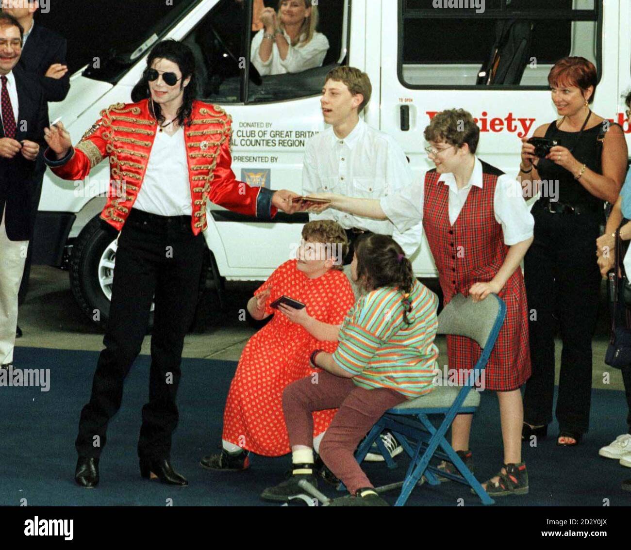 American super star Michael Jackson pictured during the handing over of Sunshine Coaches on behalf of the Variety Club of Great Britain, his wife Debbie Rowe can be seen enjoing the spectacle through the window of one of the minibuses in Sheffield, today (Wednesday). Photo by Owen Humphreys/PA. Stock Photo