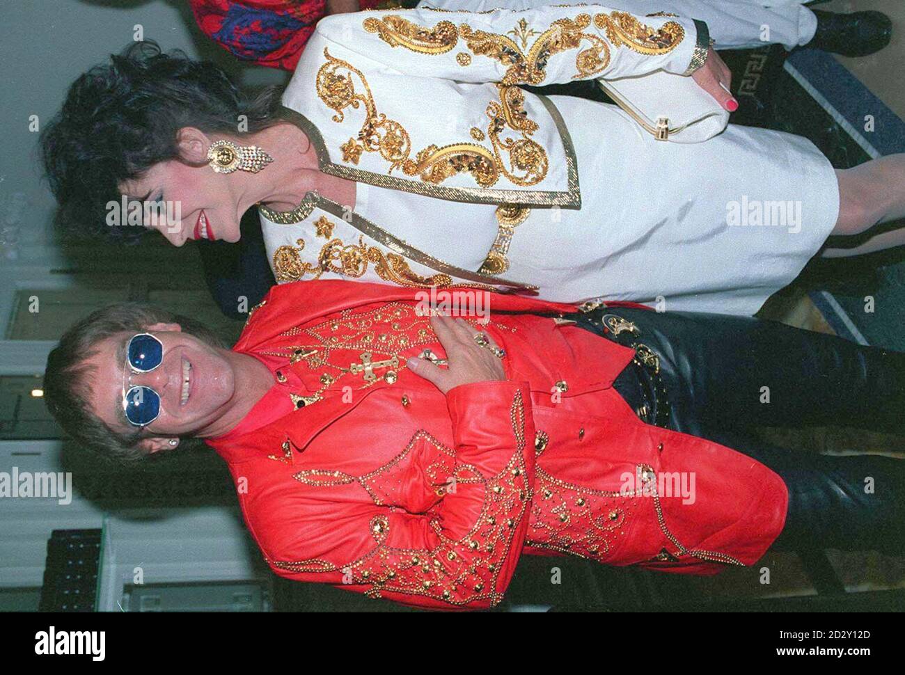 Singer Elton John with actress Joan Collins at the opening of Italian  designer Gianni Versace 's shop in London. * 15/7/97 Fashion designer  Versace, has been killed in a drive by shooting