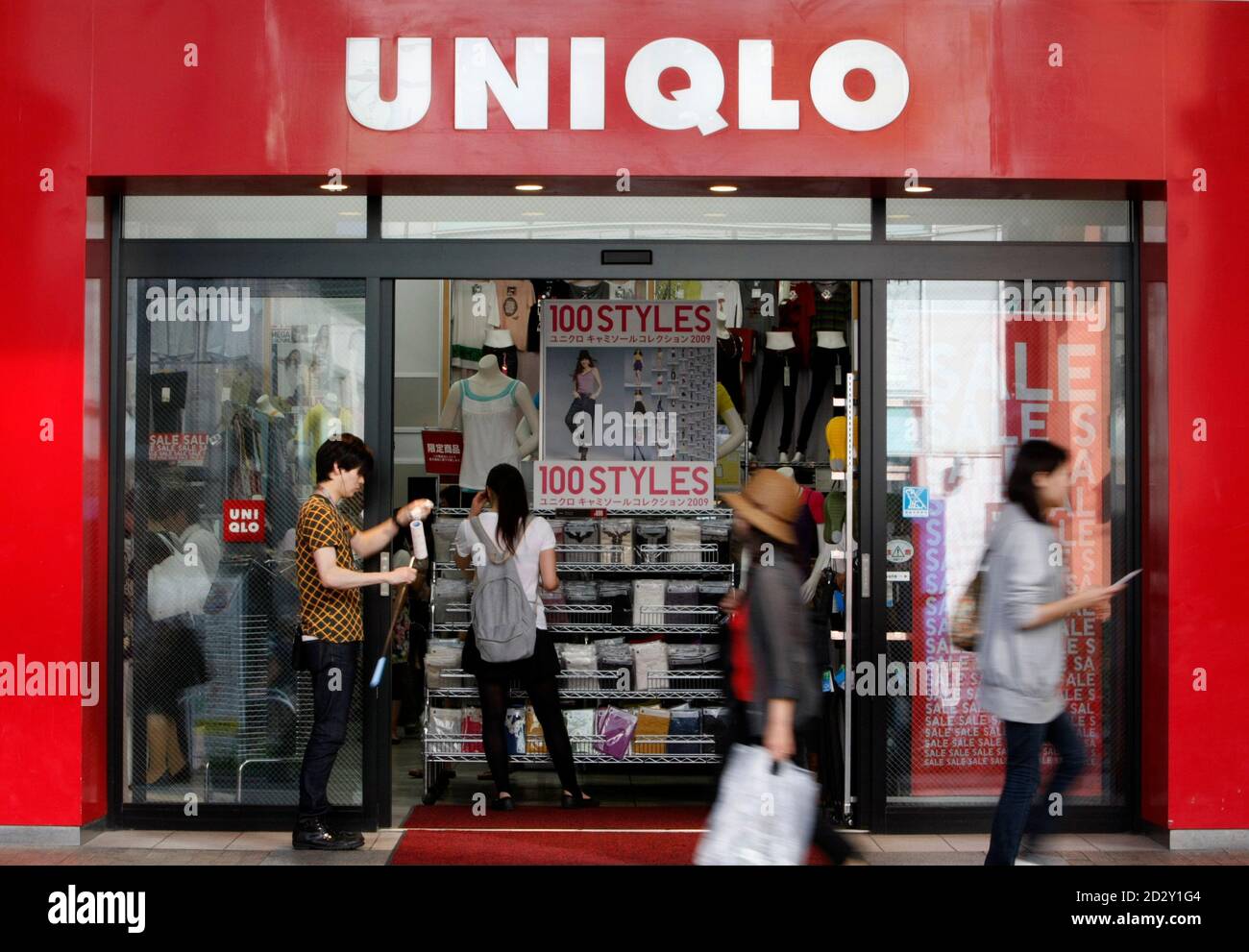 People walk past Fast Retailing's Uniqlo store in Tokyo July 9, 2009.  Japan's Fast Retailing posted a 28 percent gain in operating profit for the  first nine months of its business year