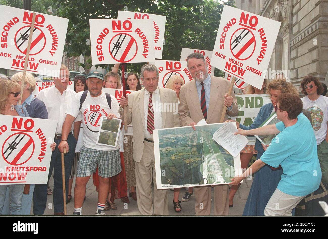 Tatton Independent MP Martin Bell, wearing his trademark white suit, and former hostage Terry Waite, holding an artist's impression of the proposed work, head a demonstration protesting against a second runway at Manchester Airport, outside Downing Street today (Tues), before handing in a petition to Prime Minister Tony Blair. See PA story ENVIRONMENT Runway. Photo by Michael Stephens/PA Stock Photo
